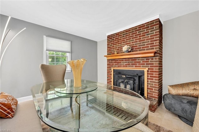 sitting room with tile patterned flooring and a brick fireplace