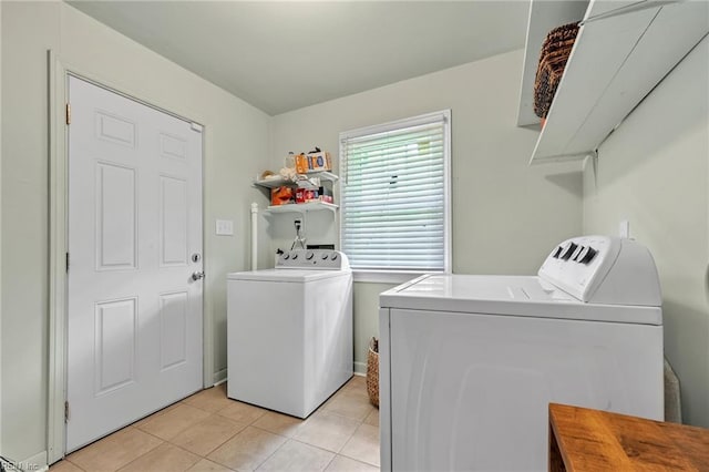 laundry area with washer and dryer and light tile patterned floors