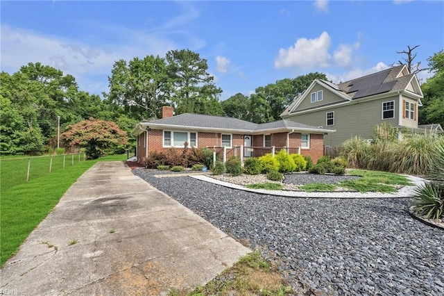 view of front of home featuring a front yard and solar panels