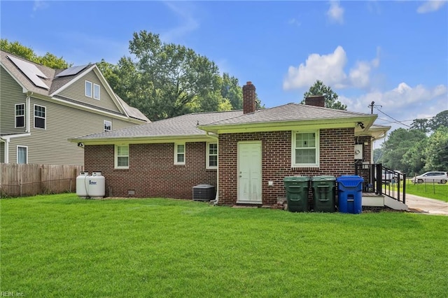 rear view of house featuring a yard and central AC