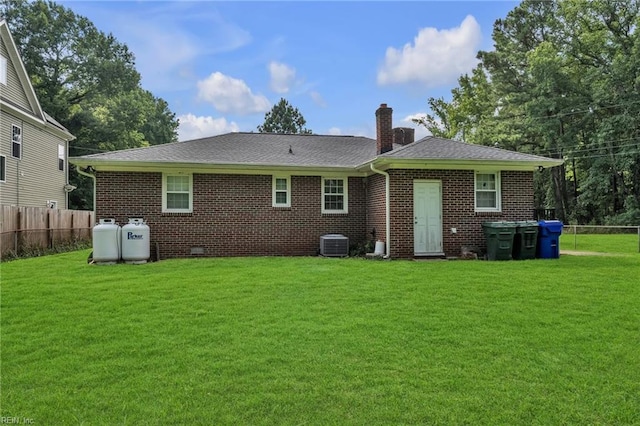 back of house featuring central AC unit and a yard