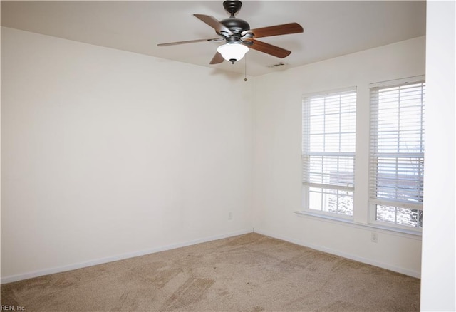 carpeted spare room featuring ceiling fan