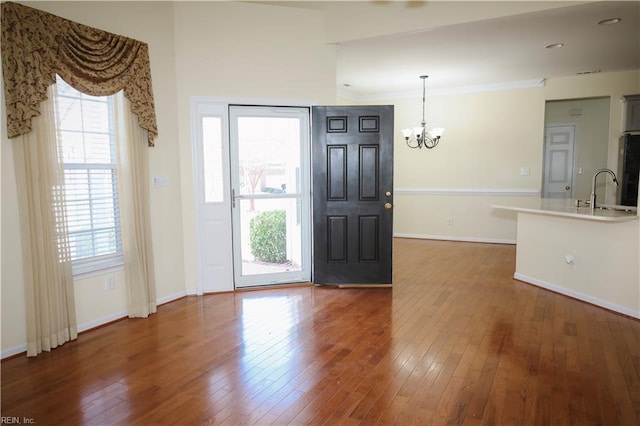 foyer featuring dark wood-type flooring, a healthy amount of sunlight, sink, and an inviting chandelier