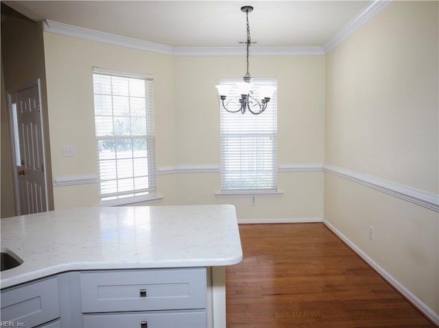 kitchen with light stone countertops, a healthy amount of sunlight, and decorative light fixtures