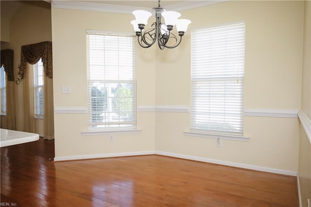 unfurnished dining area featuring ornamental molding, hardwood / wood-style floors, and an inviting chandelier