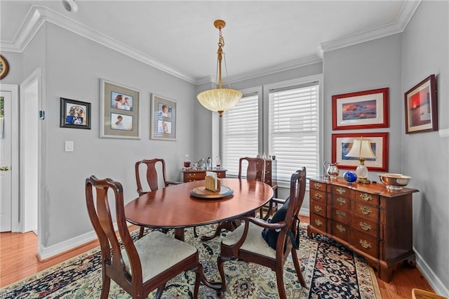 dining area with light hardwood / wood-style floors and ornamental molding