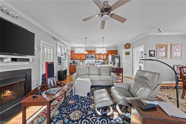 living room featuring light wood-type flooring, ceiling fan, and crown molding