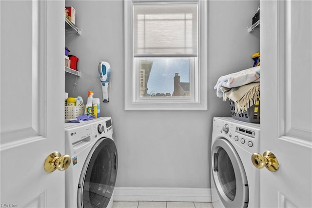 laundry room featuring washing machine and dryer and light tile patterned flooring