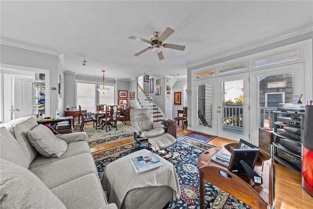 living room with light hardwood / wood-style floors, ceiling fan, and ornamental molding