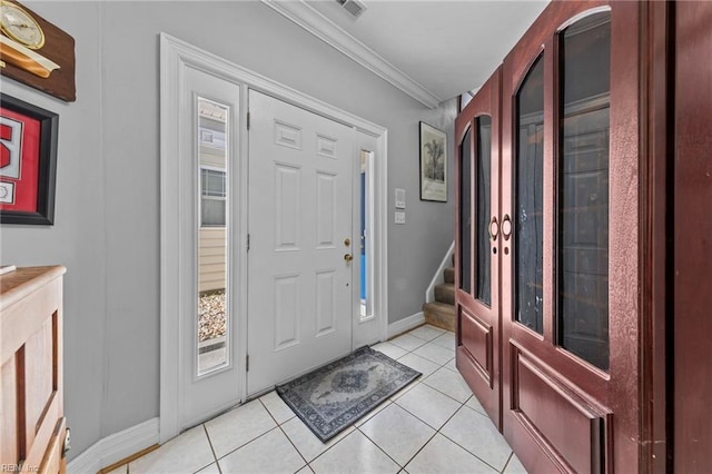 foyer entrance with light tile patterned floors and crown molding