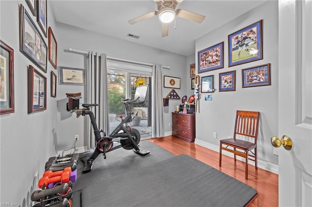 workout area with light hardwood / wood-style flooring and ceiling fan