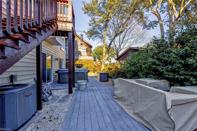 wooden terrace featuring a hot tub and cooling unit