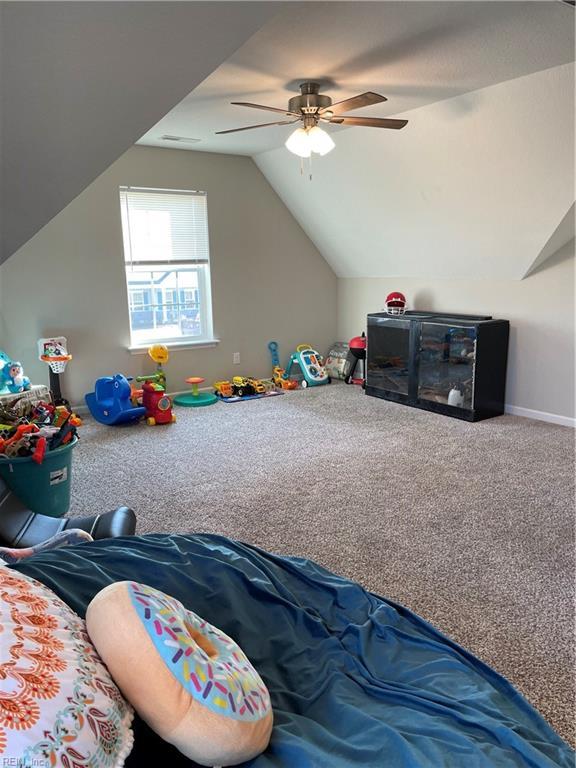 game room with vaulted ceiling, ceiling fan, carpet, and baseboards