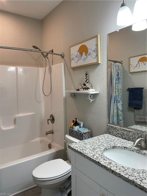 full bathroom featuring toilet, a textured wall, vanity, and shower / bathtub combination with curtain