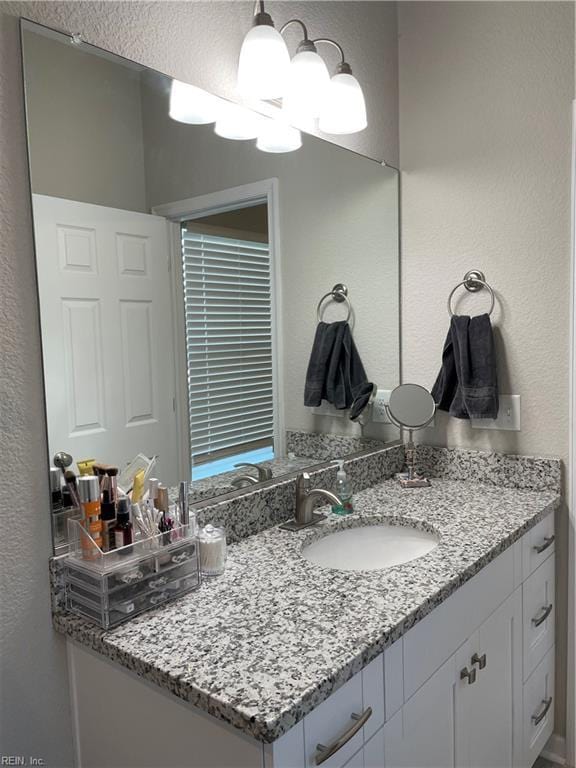 bathroom featuring a textured wall and vanity