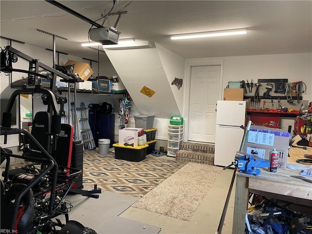 garage featuring a garage door opener and freestanding refrigerator