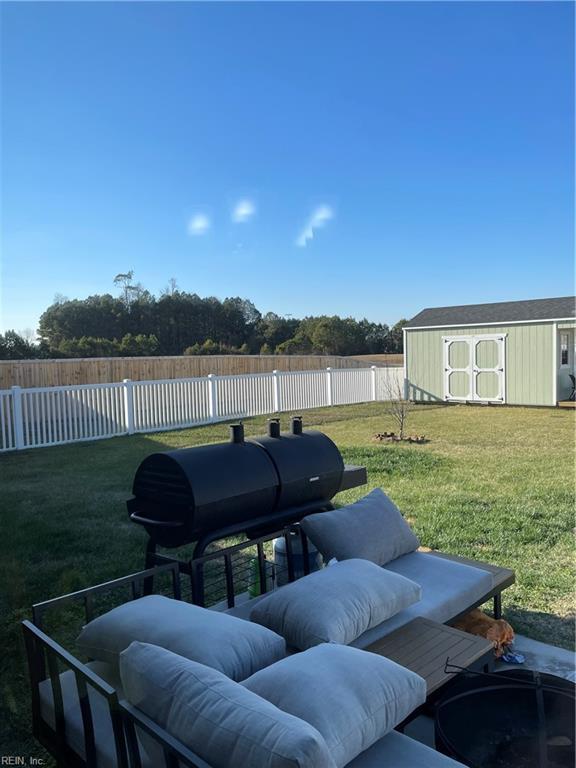 view of yard featuring an outbuilding, a storage unit, and a fenced backyard