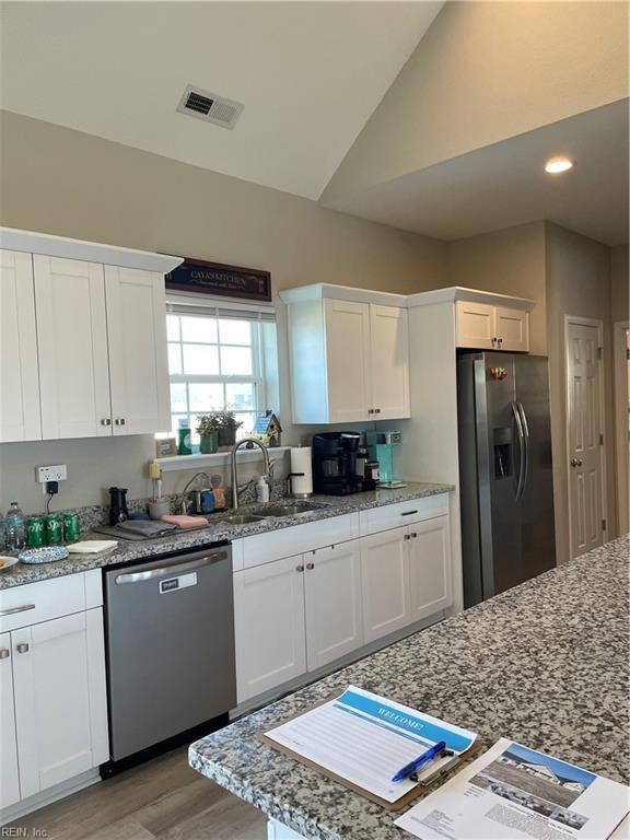 kitchen featuring white cabinetry, visible vents, appliances with stainless steel finishes, and light stone counters