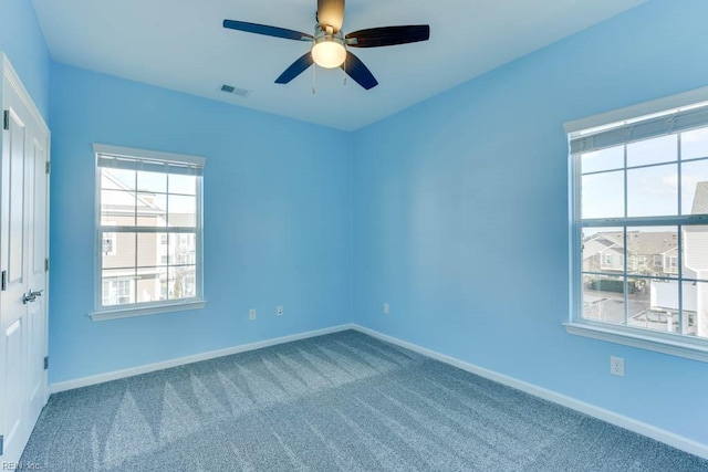 carpeted spare room featuring ceiling fan