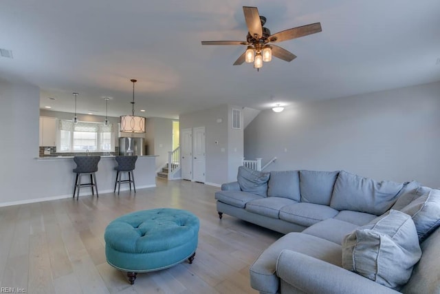 living room with ceiling fan and light hardwood / wood-style flooring