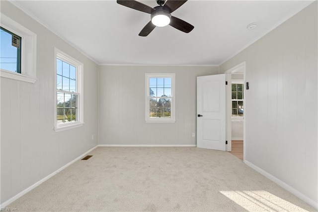 carpeted empty room with ceiling fan and ornamental molding