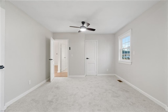 unfurnished bedroom with ceiling fan, a closet, and light colored carpet