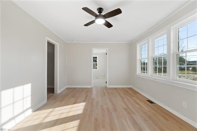 empty room featuring ceiling fan, light hardwood / wood-style flooring, and ornamental molding