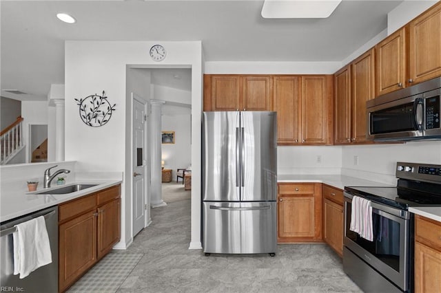 kitchen featuring stainless steel appliances, decorative columns, and sink