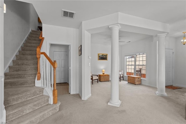 carpeted foyer featuring an inviting chandelier