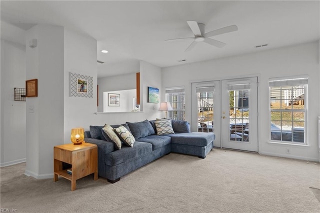 living room with french doors, light colored carpet, and ceiling fan