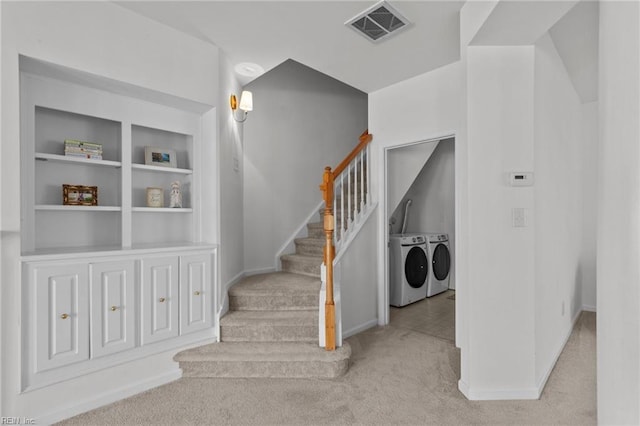 staircase with built in shelves, washing machine and dryer, and carpet floors