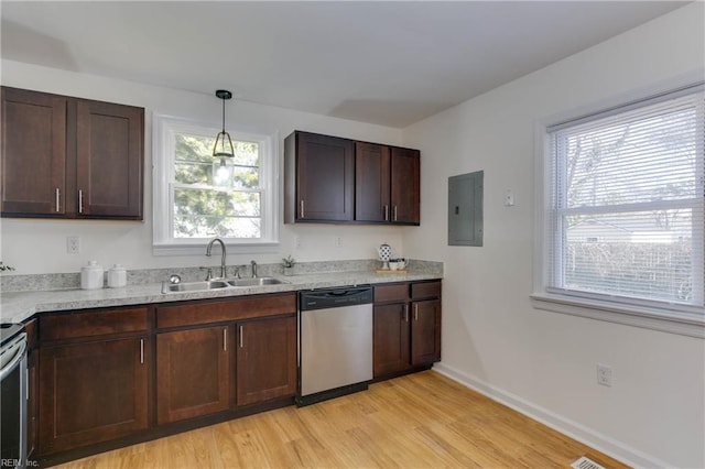 kitchen with light wood-type flooring, stainless steel appliances, sink, pendant lighting, and electric panel