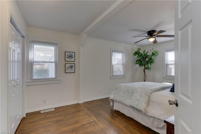 bedroom with a closet, dark hardwood / wood-style floors, and ceiling fan