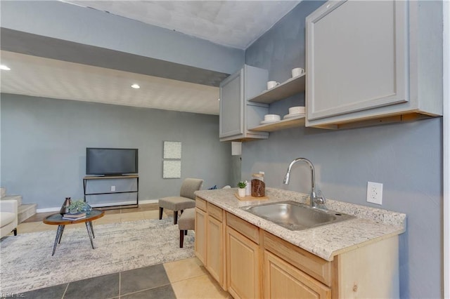 kitchen featuring light brown cabinets, light tile patterned floors, and sink