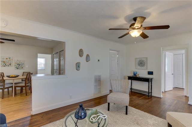 living room with ceiling fan and dark hardwood / wood-style flooring