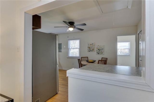 kitchen with light hardwood / wood-style floors, stainless steel refrigerator, and ceiling fan