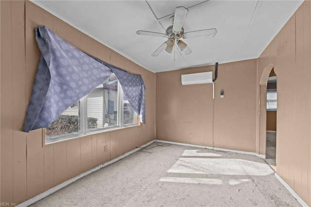 unfurnished room featuring a wall unit AC, wood walls, ceiling fan, and light carpet