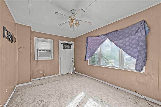 empty room with ceiling fan, wooden walls, and cooling unit