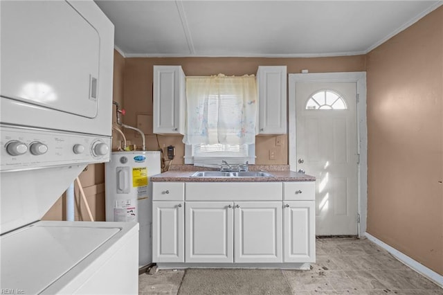 kitchen with stacked washer / drying machine, white cabinetry, sink, and water heater