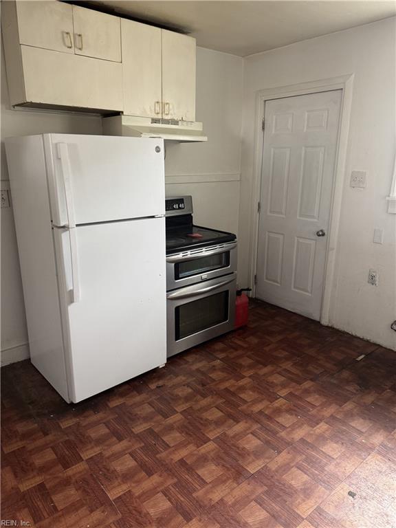 409 Hicks Ave, Norfolk, VA 23502 - kitchen featuring white cabinetry, under cabinet range hood, double oven range, and freestanding refrigerator