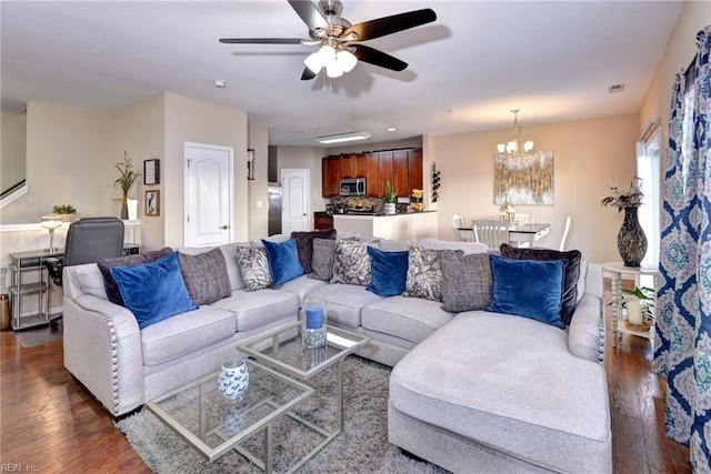 living room featuring ceiling fan with notable chandelier and dark hardwood / wood-style floors