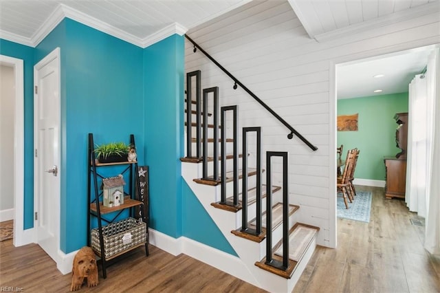 stairs with crown molding and hardwood / wood-style floors