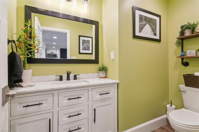 bathroom featuring hardwood / wood-style flooring, vanity, and toilet