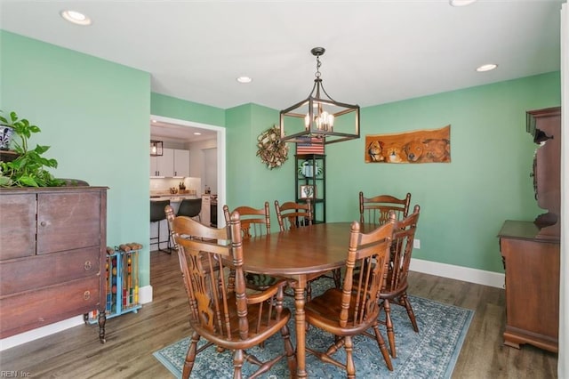 dining area featuring wood-type flooring and an inviting chandelier