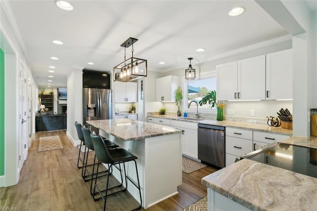 kitchen with white cabinets, a center island, stainless steel appliances, and dark wood-type flooring