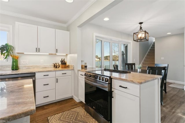 kitchen featuring white cabinets, dark hardwood / wood-style flooring, electric range oven, and hanging light fixtures