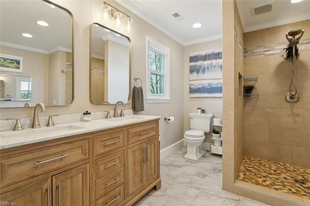 bathroom with a tile shower, crown molding, vanity, and toilet