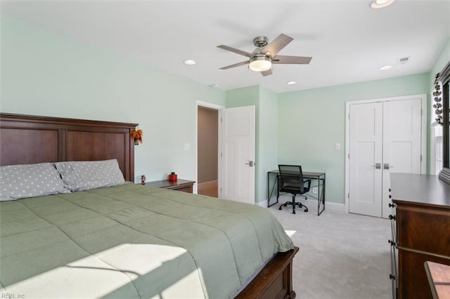 bedroom featuring a closet, light colored carpet, and ceiling fan