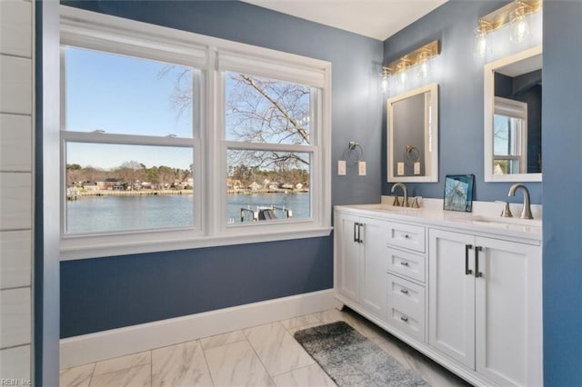 bathroom with vanity, a water view, and a wealth of natural light