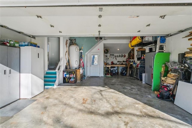 garage with a workshop area, a garage door opener, and water heater